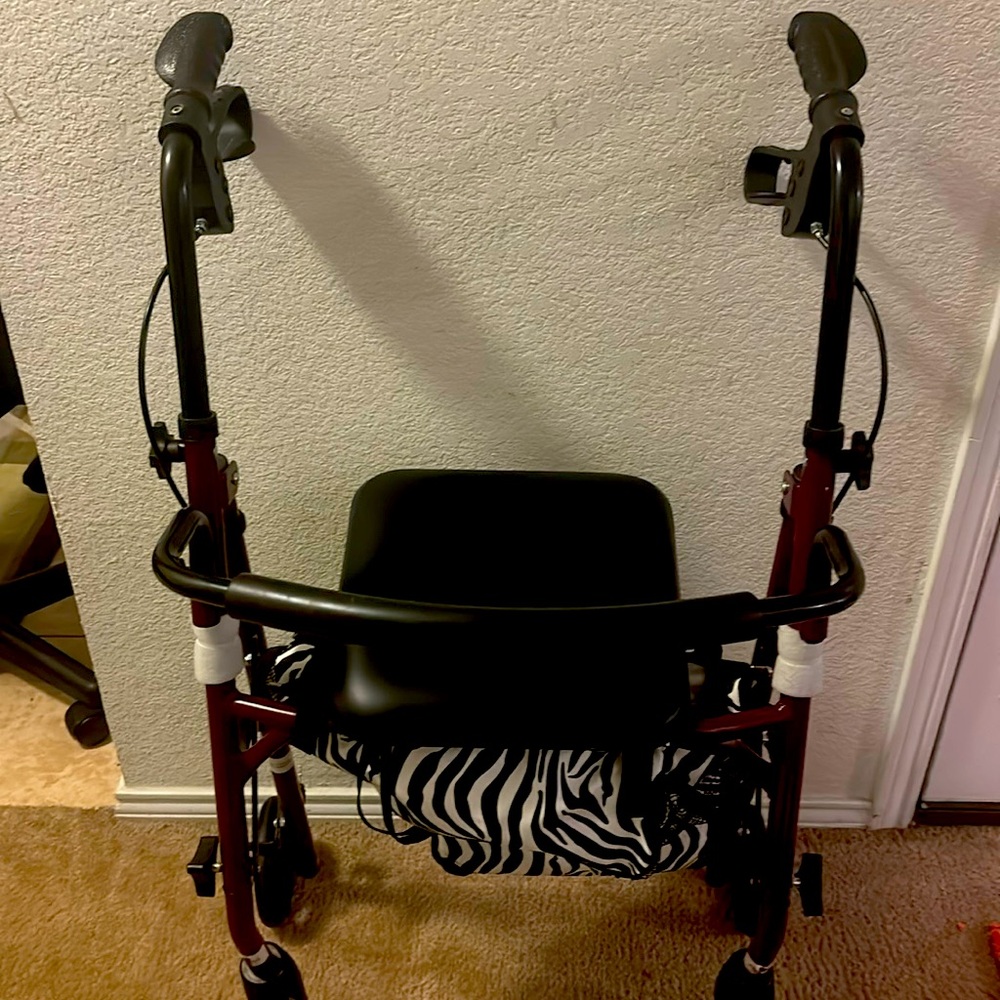 Sturdy red walker with a comfortable seat and zebra print bag.